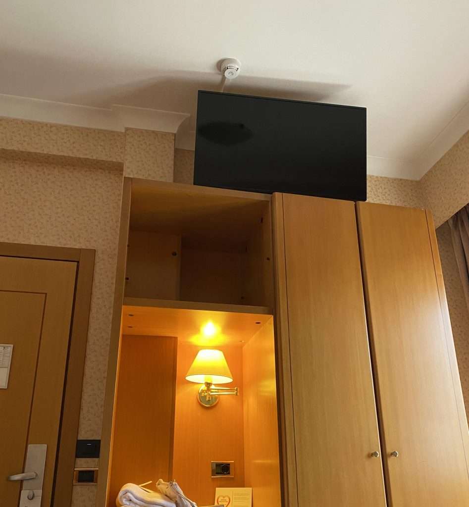 A TV mounted near the ceiling in a hotel in Italy as found on Reddit.